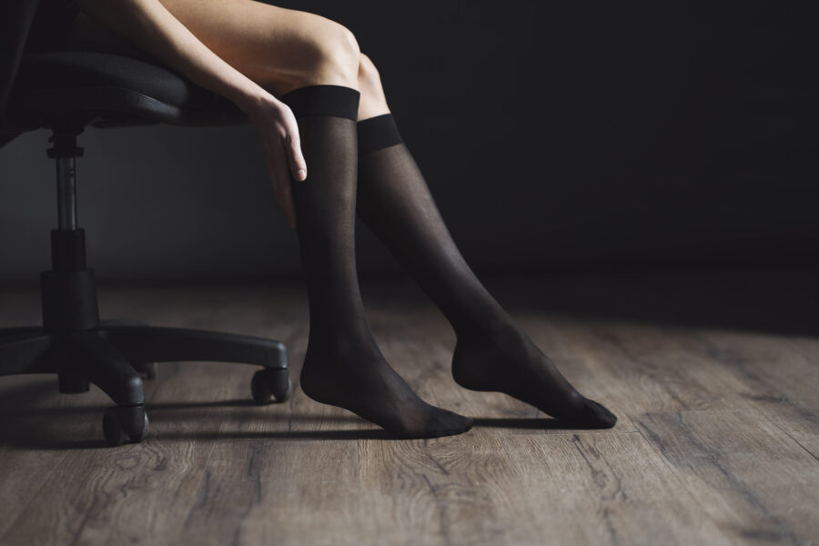 Uso de medias de compresión en las piernas durante trabajo sentado, imagen utilizada por Farmavari en contenidos de bienestar laboral